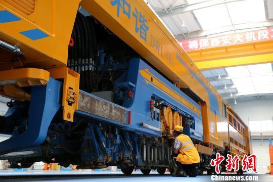 圖為工人正在清理大型養(yǎng)路機(jī)械?！堖h(yuǎn) 攝